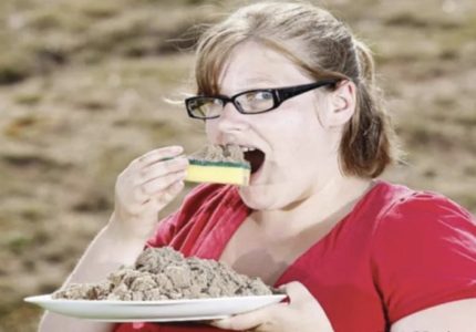 Девушка ест песок