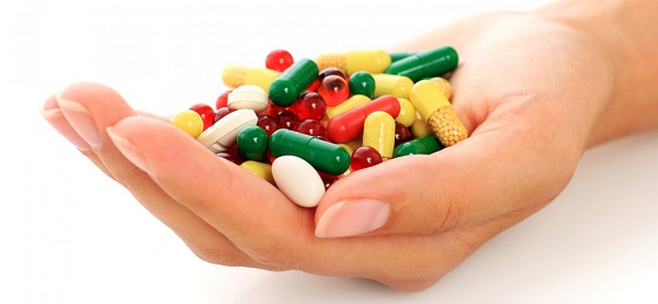 Витамины в таблетках и капсулах в ладони